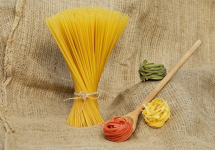 assorted-color pasta with brown wooden ladle