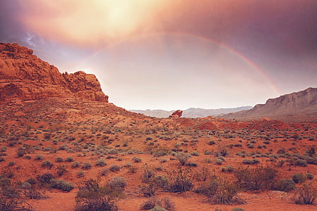 rainbow across valley during golden hour