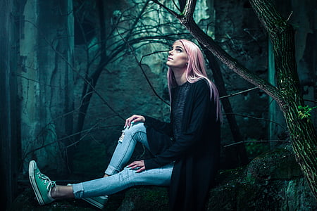 woman wearing jeans and shirt sitting on woods