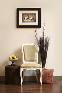 white wooden framed padded chair under painting with framed hanged on wall