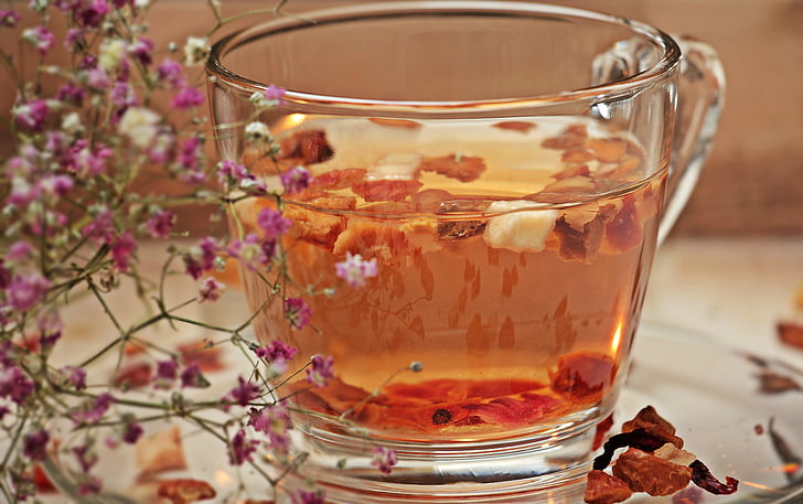 clear glass teacup filled with orange liquid in closeup photo