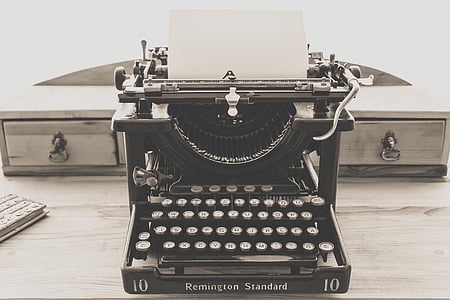 black Remington Standard typewriter on top of beige wooden surface