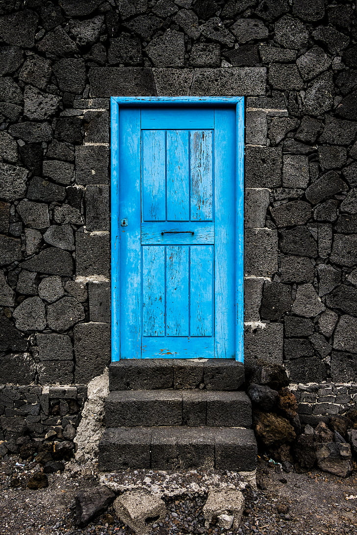 blue wooden door on gray concrete structure