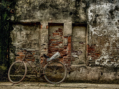 brown and grey bicycle parked near brown concrete building