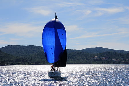 blue and white sail boat sailing during daytime