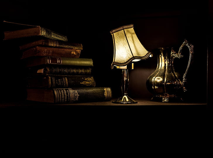 photo of white table lamp near books