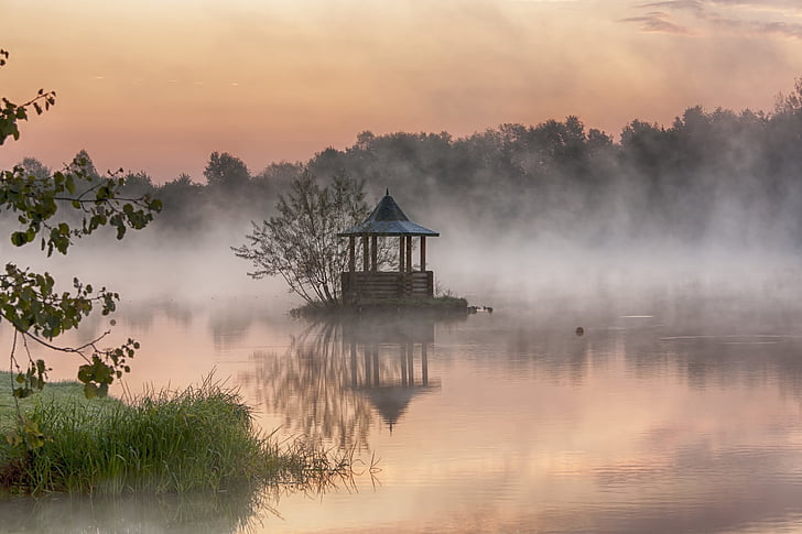 brown gazebo on body of water surrounded of trees during golden hour