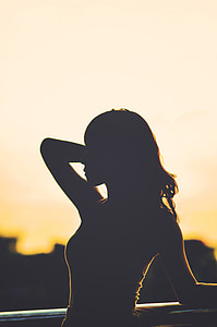 silhouette photography of woman holding her hair