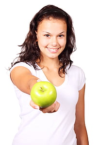 woman wearing white v-neck t-shirt holding green apple