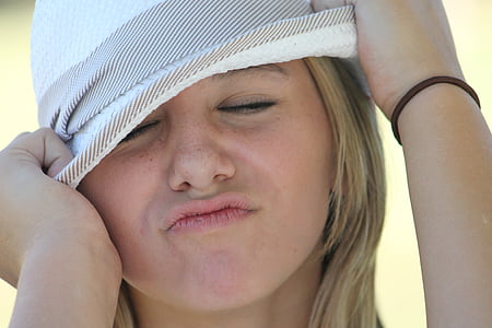 woman with pouty lips wearing white hat