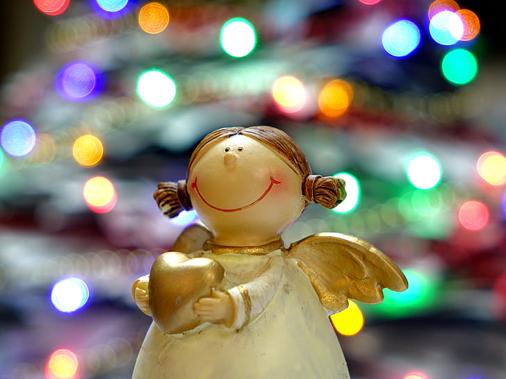 angel holding heart figurine with bokeh light