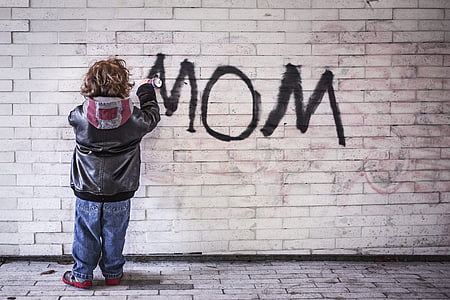 photo of child spraying wall with mom text