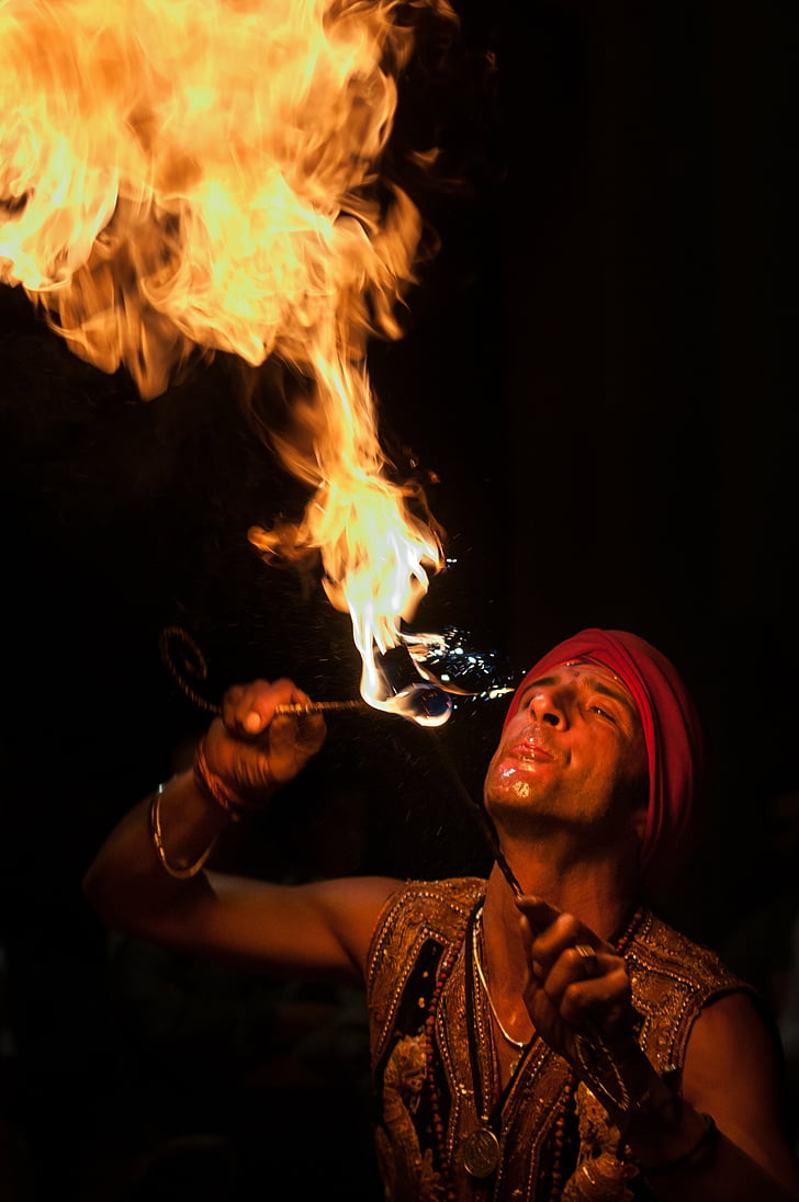 man wearing red bandana breathing fire