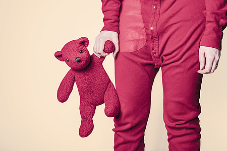 person holds pink teddy bear