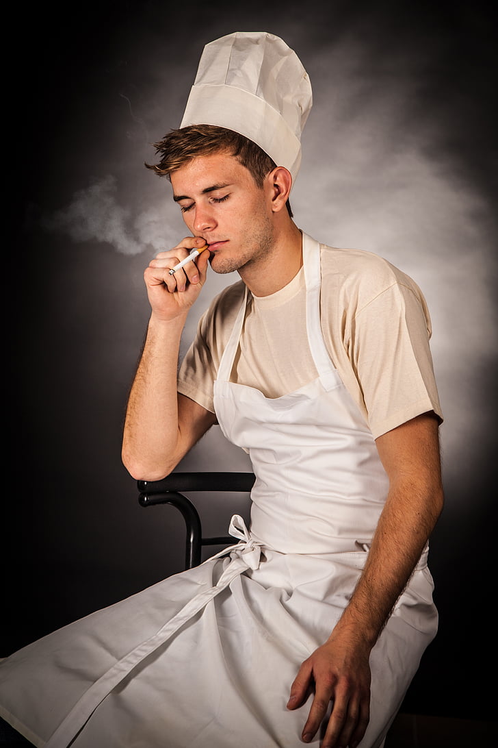 man in white apron smoking cigarette