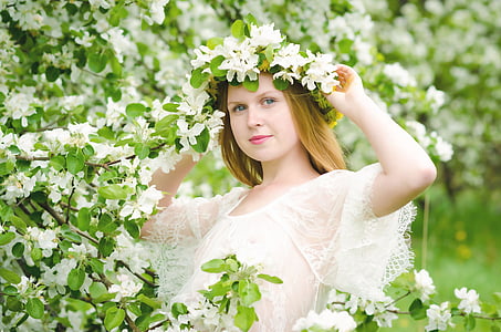 photo of woman wearing white lace short-sleeved scoop-neck top and white petaled flower headband