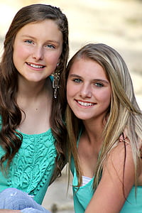two girls wearing green sleeveless tops