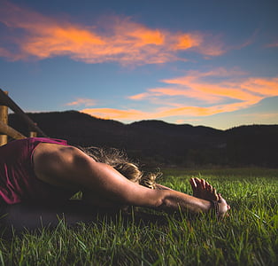 woman sitting on grass doing stretching
