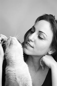 woman playing with cat in gray-scale photography