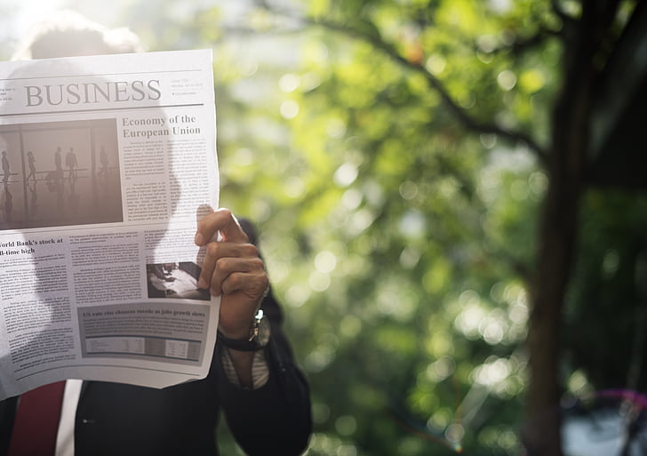 man reading business section of newspaper