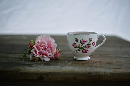 white and pink floral ceramic cup with coffee