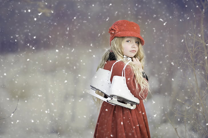 woman wearing red coat holding figure skate while raining snow