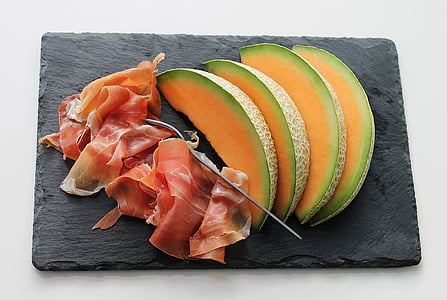slice of bacon and fruits on rectangular black chopping board