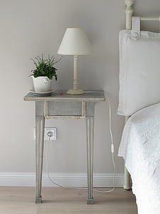 white table lamp near white pot on grey wooden end table