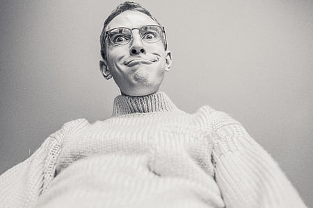 grayscale photo of man wearing knit sweater and eyeglasses