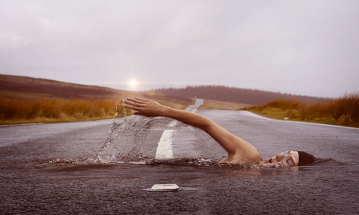 edited photo of man swimming on asphalt road