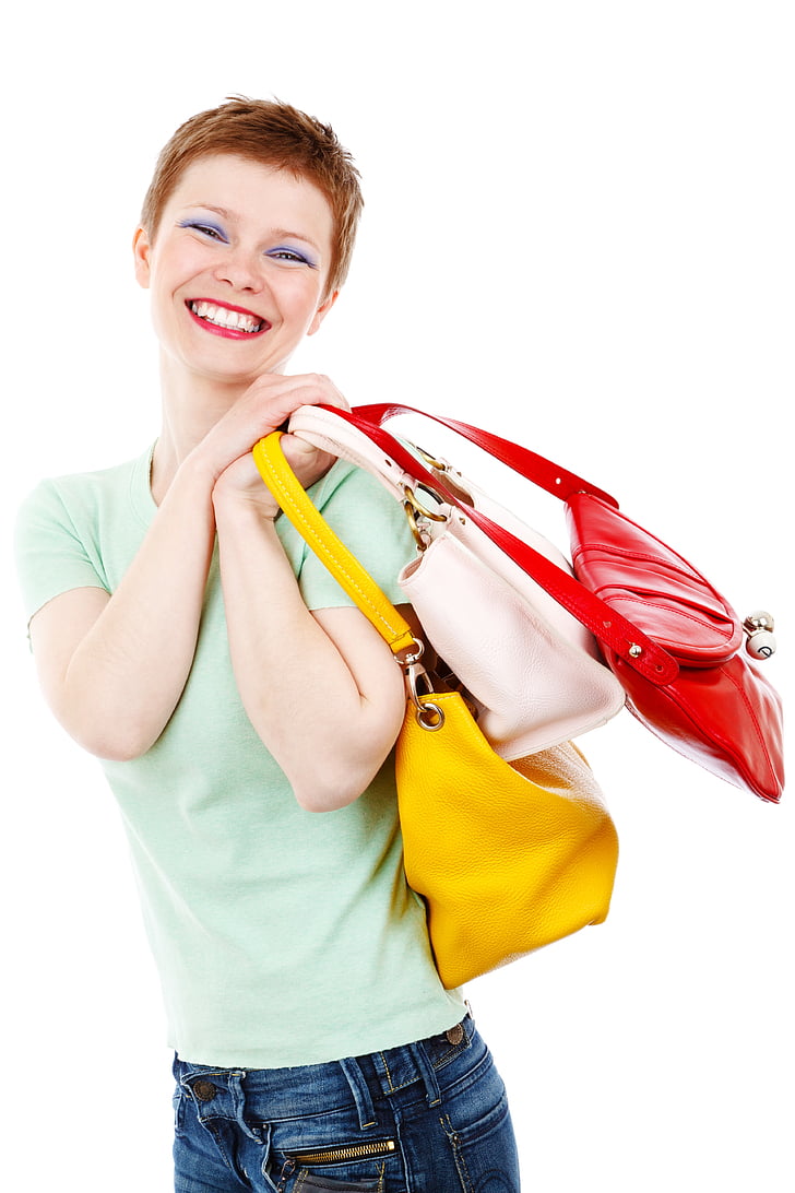 woman holding three assorted-color handbags