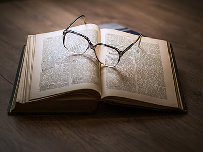eyeglasses on top of opened book
