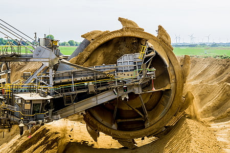 gray industrial machine at cultivates sand at daytime