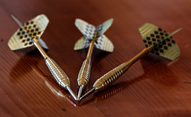 three silver-colored dart pins