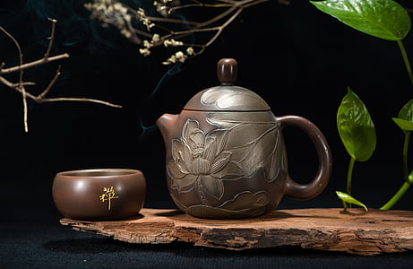 brown floral tea pot and bowl near green leaf plant