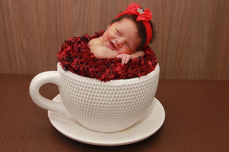 white ceramic mug and saucer with baby sleeping