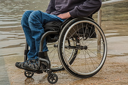 person sitting on gray folding wheelchair