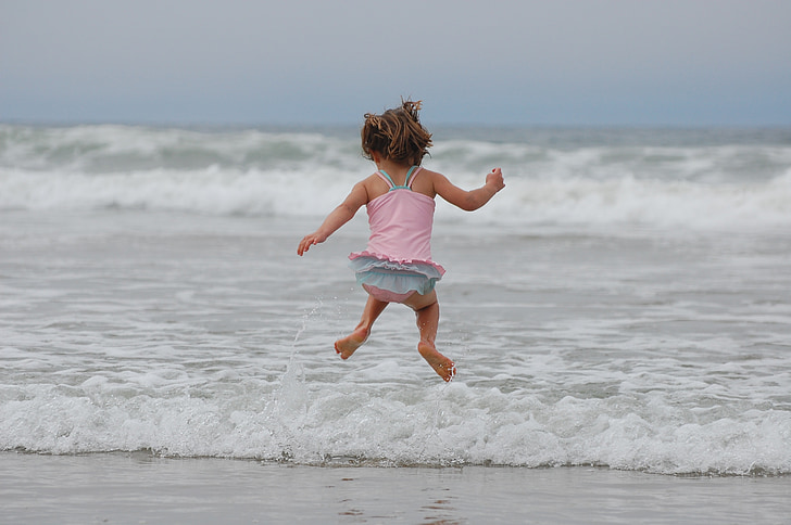 timelapse photography of girl jumping by the seashore