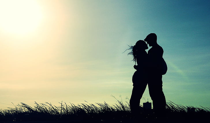 silhouette of man and woman on grass