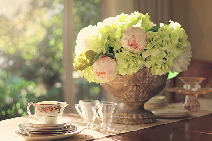 green hydrangea and pink buttercup flower arrangement and clear glasses