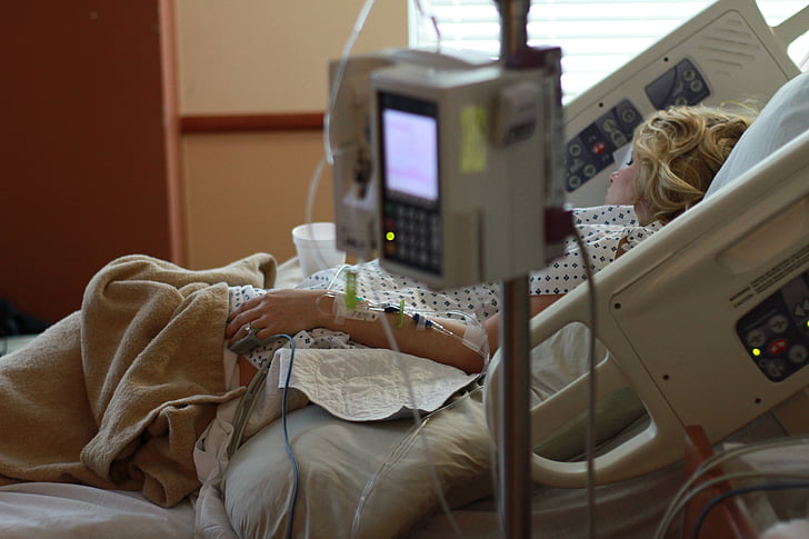 woman lying on hospital bed inside hospital