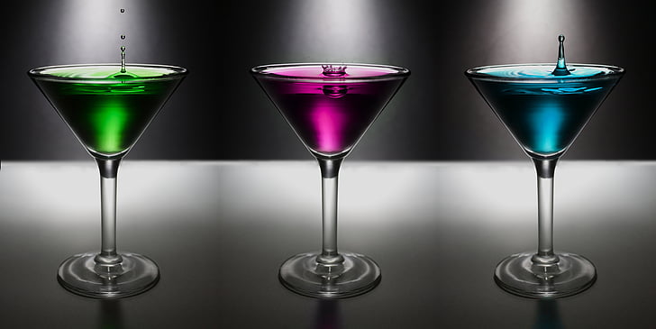 three cocktail glasses filled with assorted-color liquors