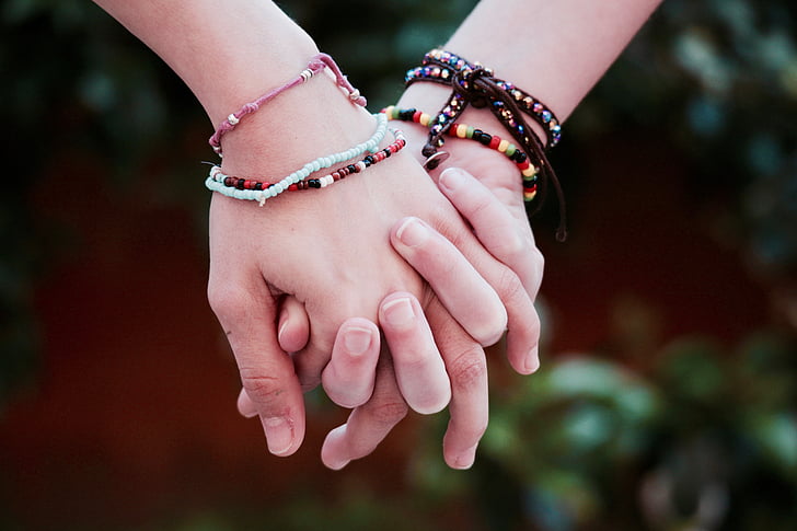 person's wearing multi-colored friendship bracelets