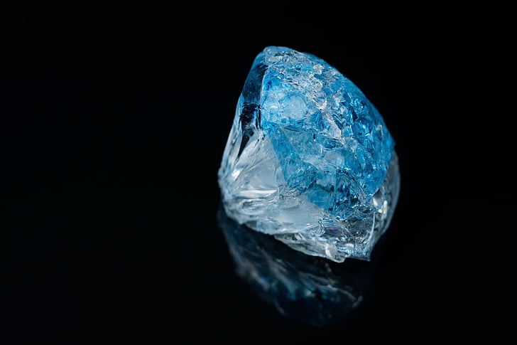 round blue gemstone with black background