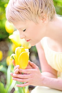 woman smelling yellow tulip flower