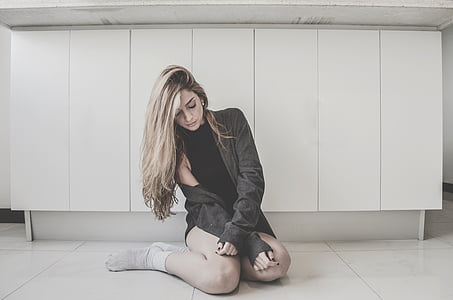 woman in black top sitting on floor