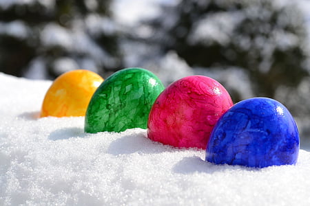 shallow focus photography of yellow, green, pink, and blue stone fragments on snow