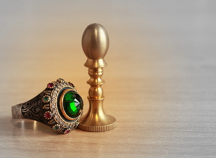 silver-colored ring with green gemstone