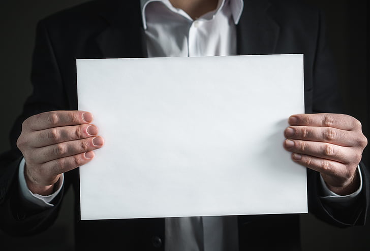 person holding white printing paper