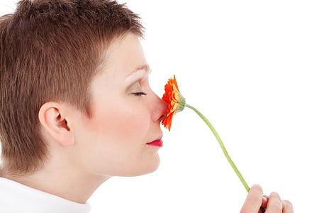 woman holding red flower white smelling
